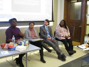 Four students in the front of a classroom discussing their research